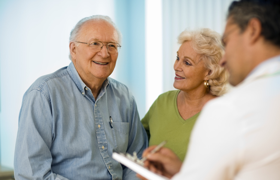 Senior couple smiling while talking to a provider